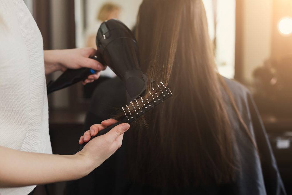 Beautician drying woman's hair